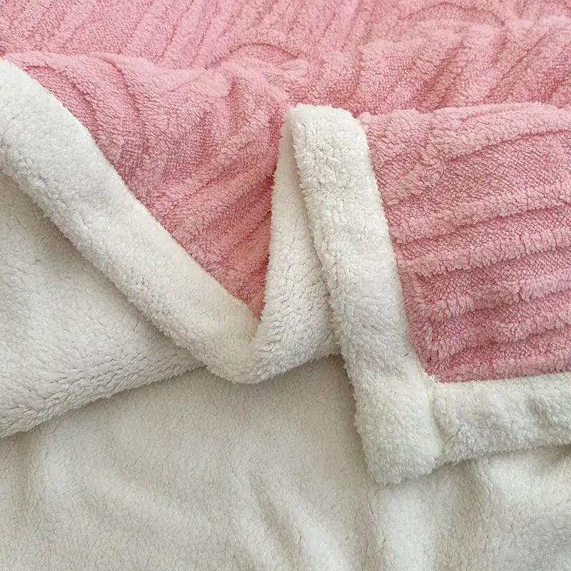 Pink and white double layered flannel plush blanket with a textured wave pattern and fleece border for bedroom use