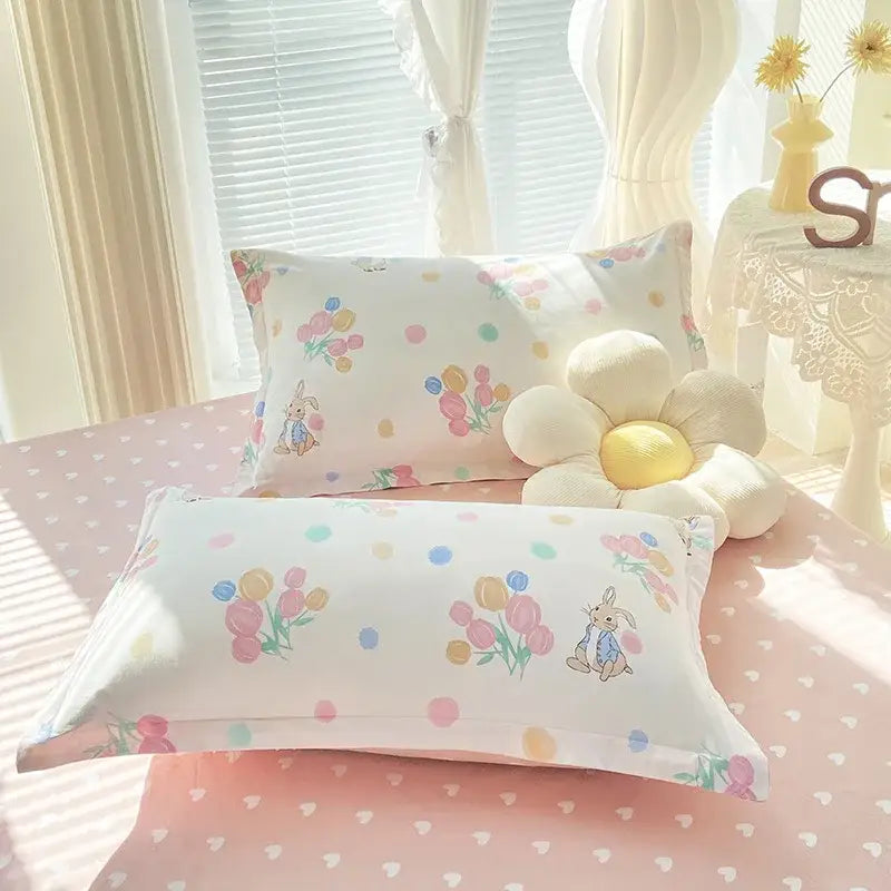 White pillowcases with pastel tulips and bunny illustrations in a decorbites cotton printed bedding set with satin finish