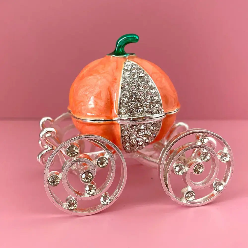 Pink and white rhinestone crown carriage jewelry trinket box shaped like orangish-pink pumpkin with silver accents and green stem