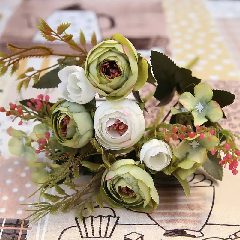 A delicate pink and white silk tea rose ranunculus bouquet with green accents crafted from synthetic materials for wedding decor