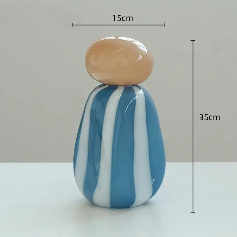 Glossy blue and white striped ceramic figurine with beige head featured as a decorative vase cover band for living room