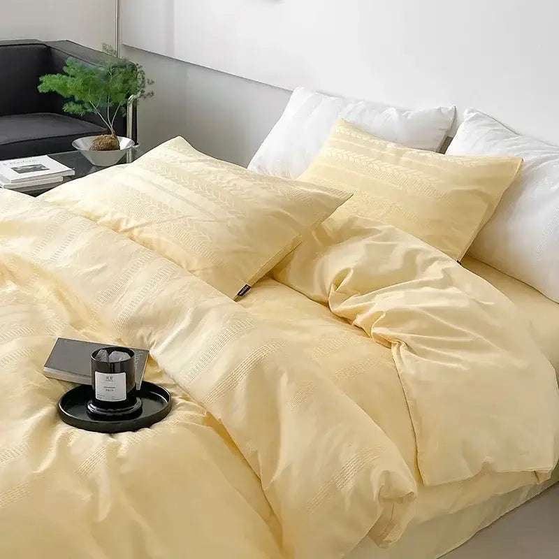 Soft pale yellow satin-like bedding set with subtle texture complementing pink and white striped jacquard cotton bedding