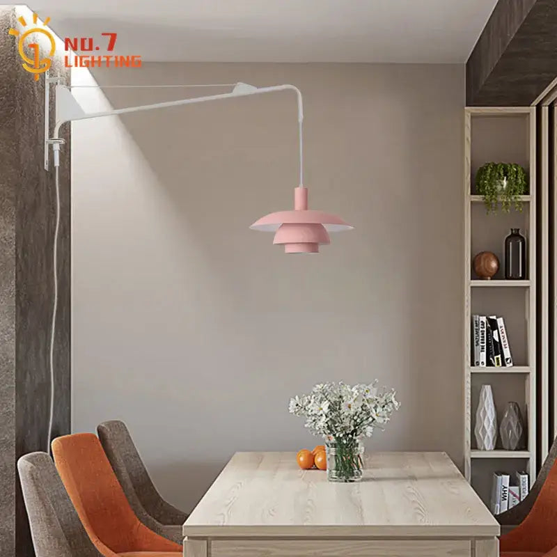 Pink tiered pendant wall lamp with white articulated swing arm and wind rotating feature for bedroom use