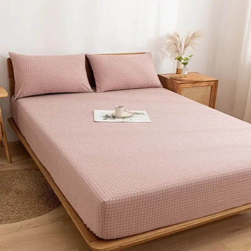 Pink grid-patterned cotton fitted sheet with matching pillows on wooden bed frame showcasing decorbites cotton fitted sheet