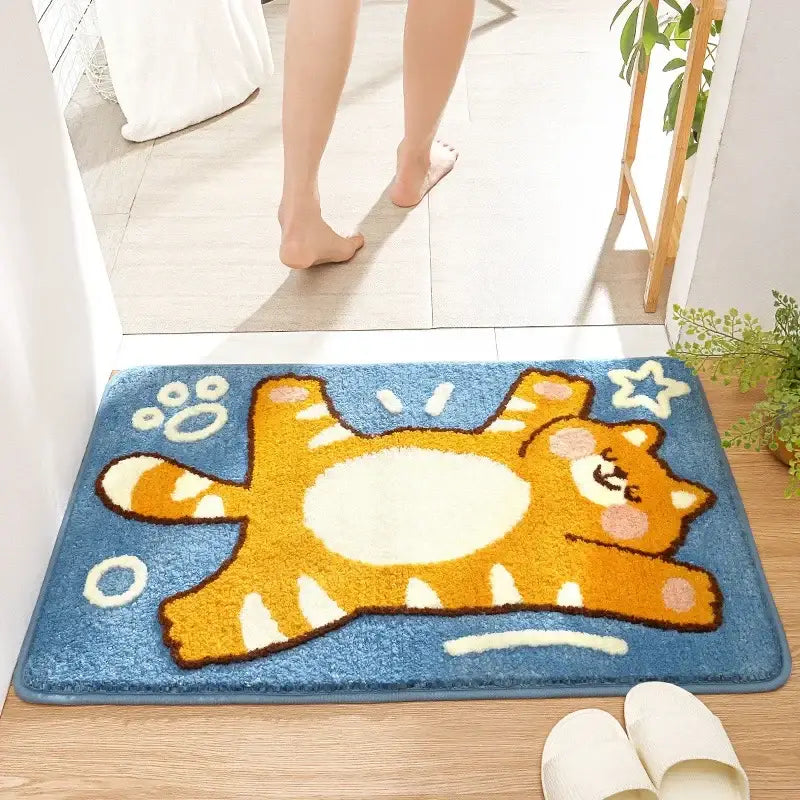 Blue plush bath rug featuring a cheerful orange tabby cat with white accents and paw prints for decorbites cartoon animal bathroom decor