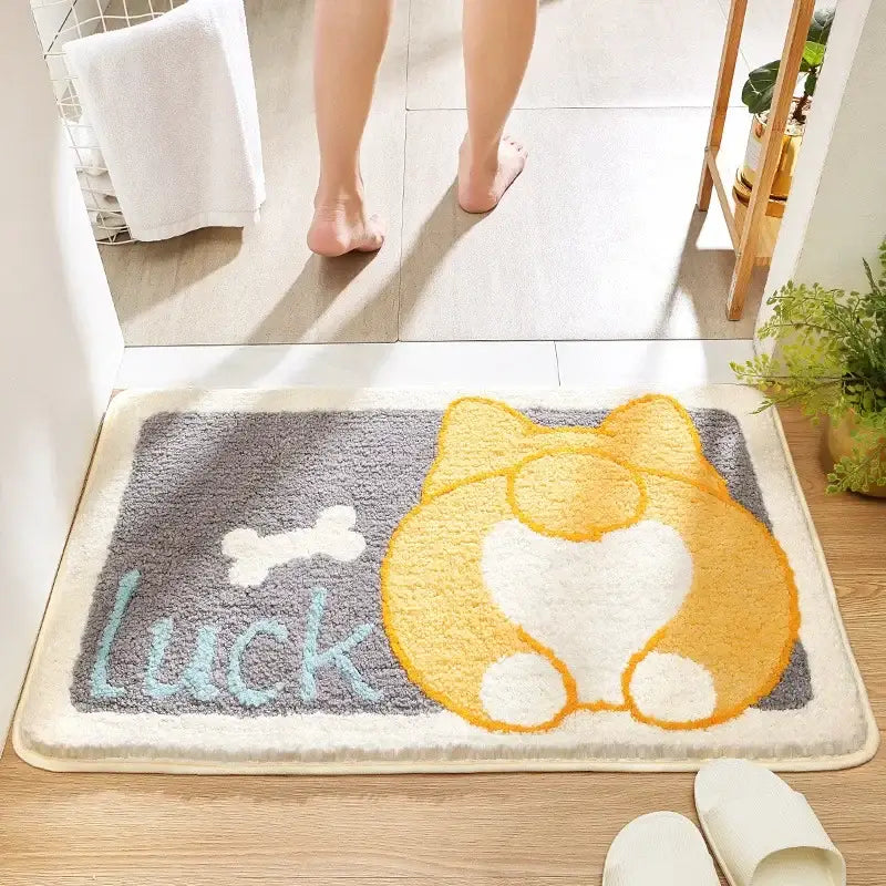 A plush gray decorbites cartoon animal bath rug featuring a cheerful yellow and white corgi with luck lettering