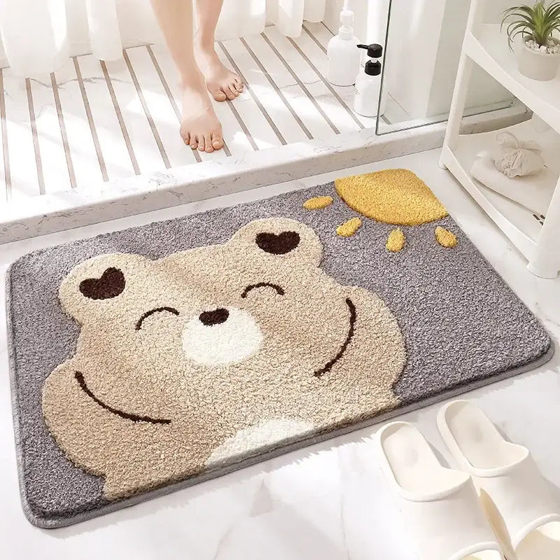 Gray plush bath rug featuring a smiling beige bear with heart eyes and yellow sun decorbites cartoon animal design