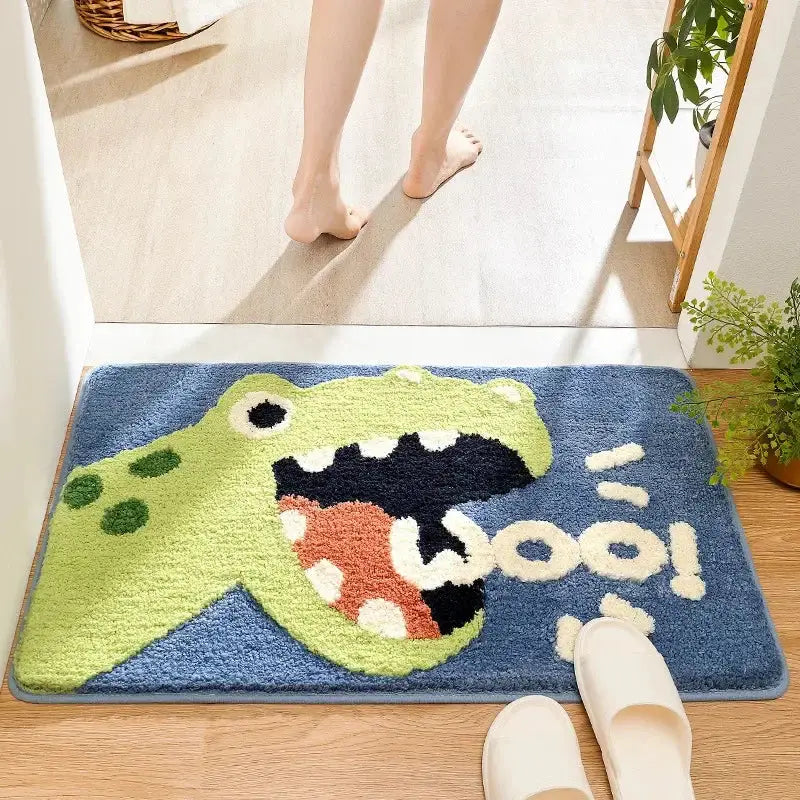 A plush blue bath rug featuring a bright green cartoon animal dinosaur and cream wooo lettering for cartoon animal bathroom decorbites