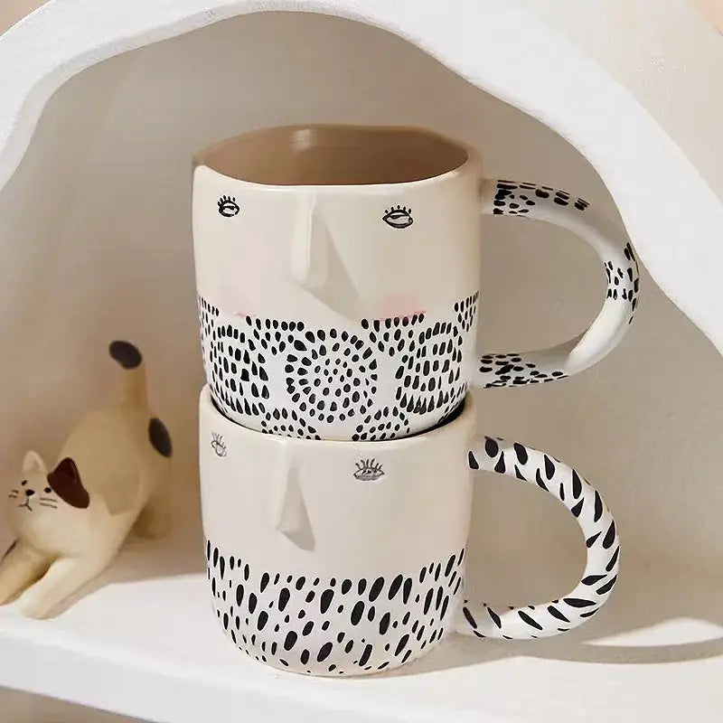 Two stacked white ceramic coffee milk mugs with black spotted patterns and playful stylized face design 340ml capacity