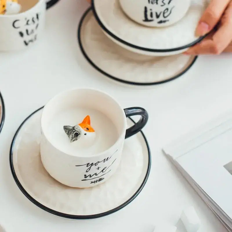 White ceramic cup with black rim and handle featuring you and me inscription and fox figurine decorbites cat claw ceramic