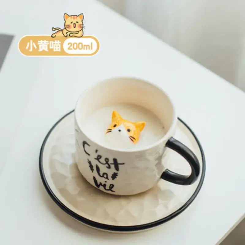 White ceramic cup with black handle and orange cat figurine inside creamy beverage decorbites cat claw ceramic mug