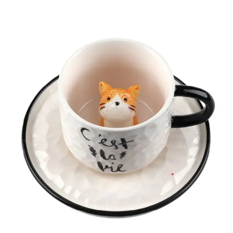Playful white and black ceramic cup with c’est la vie script and orange decorbites cat claw figurine inside
