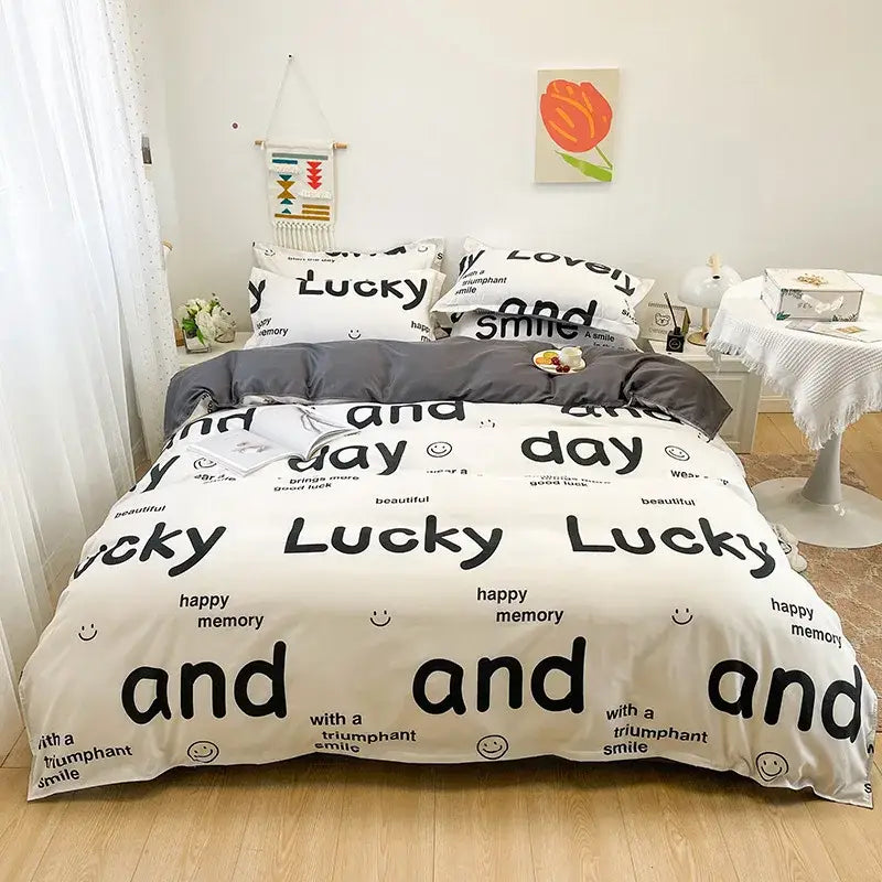 White and gray bedding set with bold black lucky and smiley face text patterns in playful dog print bedding decor