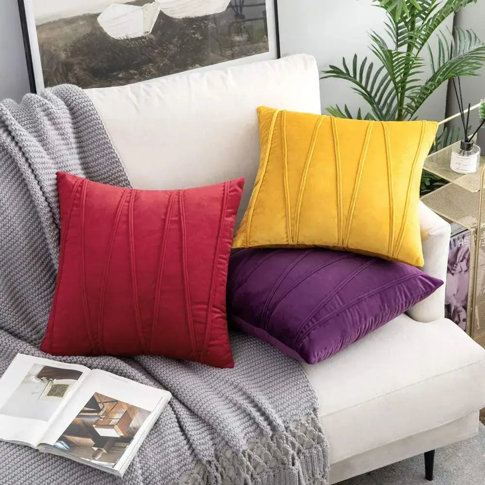Three vibrant velvet throw pillows in red yellow and purple with vertical pleated detailing on a white sofa short wool velvet decorbites knit short