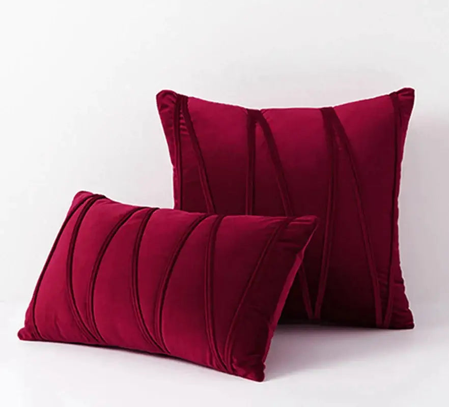 Deep red velvet pillows with vertical pleated detailing complement knit short wool velvet decor for living room use