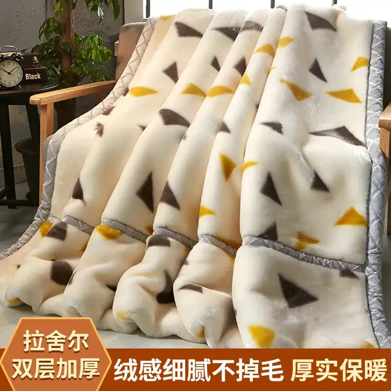 Cream-colored plush raschel blanket with black and yellow geometric pattern and gray quilted border for winter decorbites use
