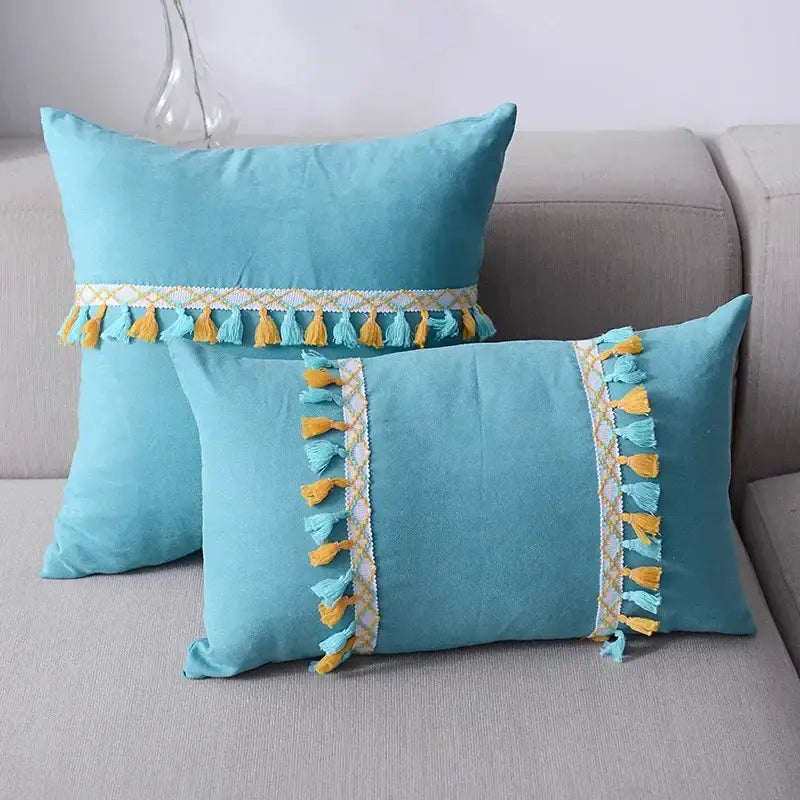 Turquoise rectangular cushion with yellow and light blue tassels displayed alongside plush black and white decorbites houndstooth cushion cover
