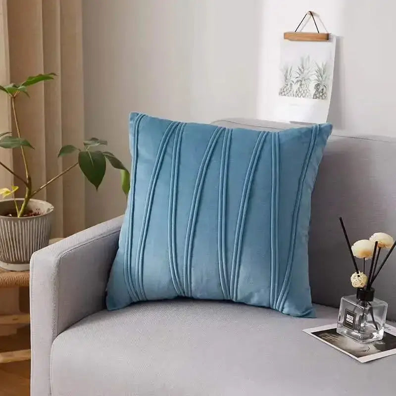 Blue velvet throw pillow with vertical pleats paired with a plush black and white decorbites houndstooth cushion cover
