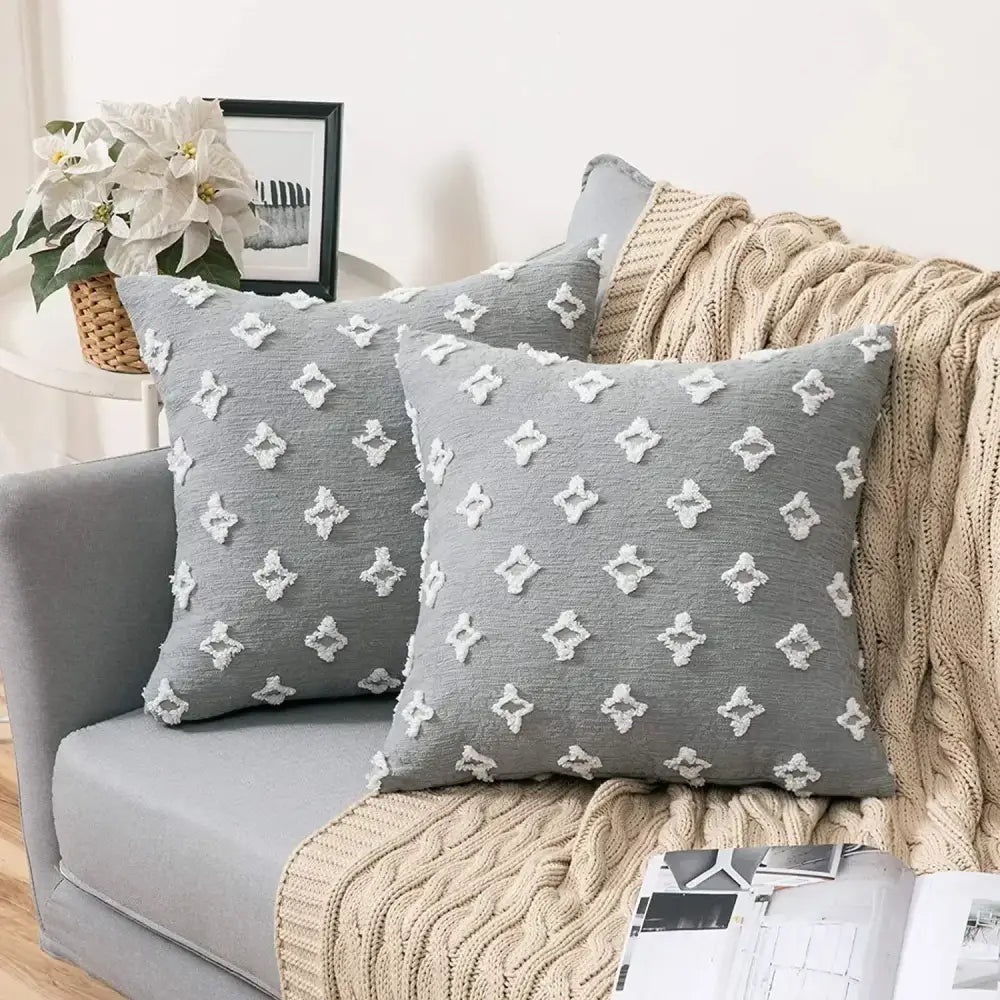 Plush black and white houndstooth cushion cover with gray throw pillows featuring white embroidered diamond patterns