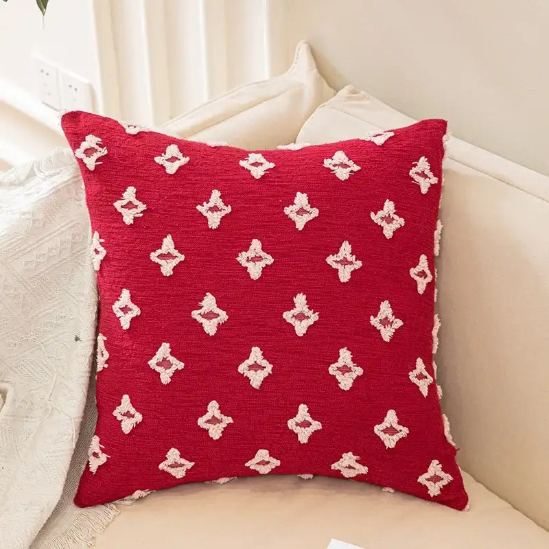 Red cushion with white embroidered diamond patterns shown with plush black and white decorbites houndstooth cushion cover