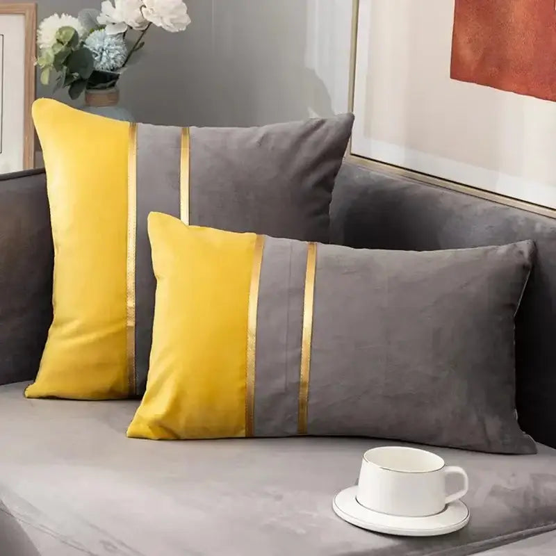 Two rectangular velvet throw pillows with bold yellow gray panels and gold stripes complement a houndstooth cushion cover