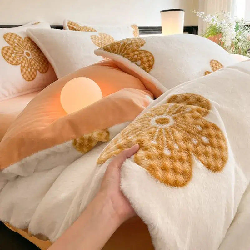 A plush white comforter with golden-brown floral appliqués in a decorbites cozy rabbit hair bed set