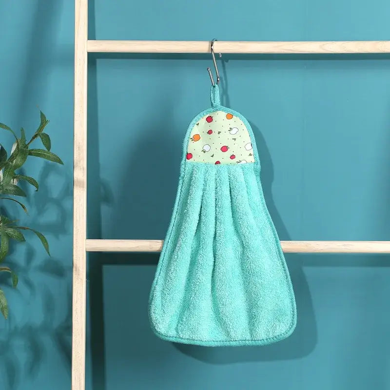 A turquoise terry cloth hand towel with a colorful patterned top panel hanging on a metal hook for kitchen decorbites coral velvet hand use