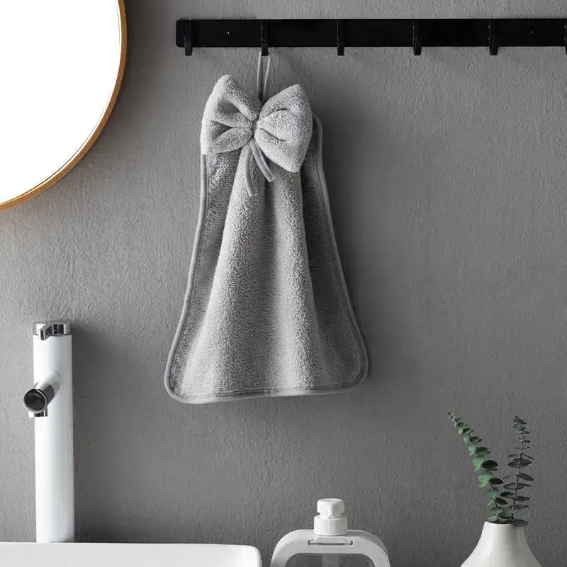 Gray decorbites coral velvet soft hand towel with decorative bow hanging on black rack for kitchen and bathroom decor