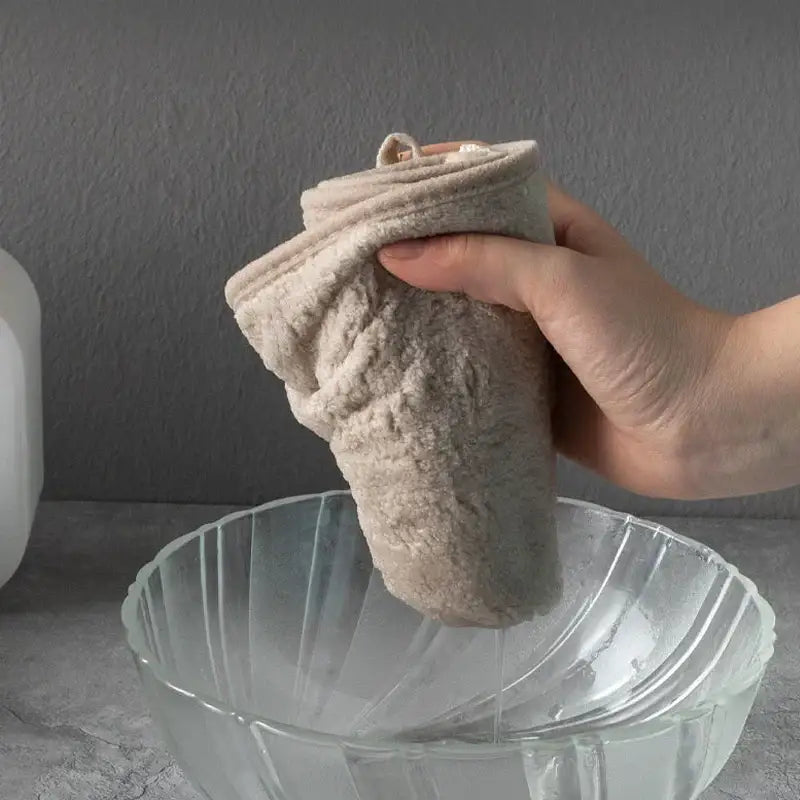 Beige plush coral velvet soft hand towel with bow held above glass bowl for kitchen and bathroom use decorbites coral velvet