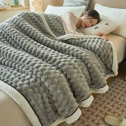 A cozy gray plush flannel fleece blanket with raised pom-pom texture and cream ribbed trim by decorbites cozy flannel