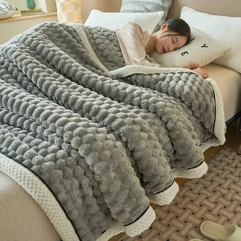 A cozy gray plush flannel fleece blanket with raised pom-pom texture and cream ribbed trim by decorbites cozy flannel