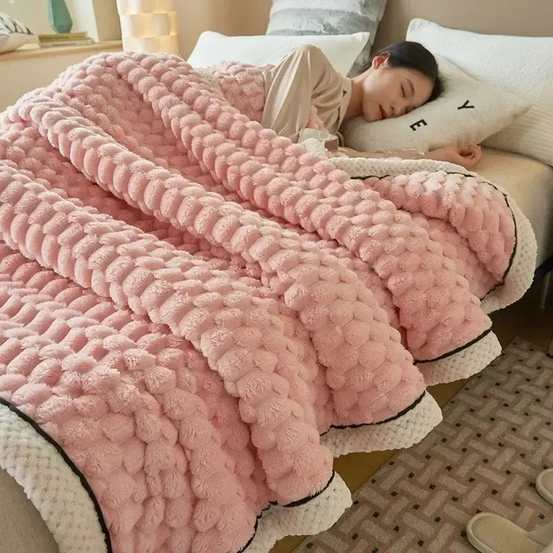Pink chunky knit throw blanket with white and black trim paired with plush cream and black cozy flannel fleece blanket