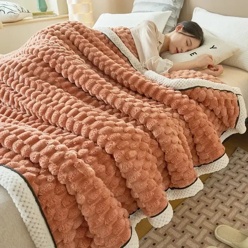 A plush peach-colored cozy flannel fleece blanket with raised pom-pom texture and white trim for decorbites cozy flannel decor