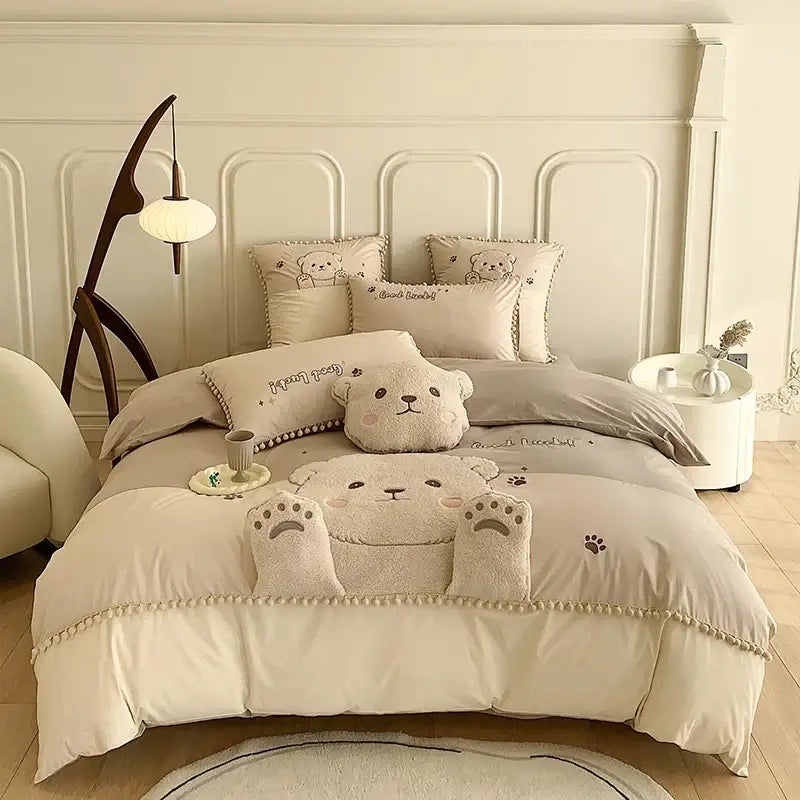 Cream-colored plush cotton bedding set featuring cartoon bear applique with soft textured fabric and embroidered details