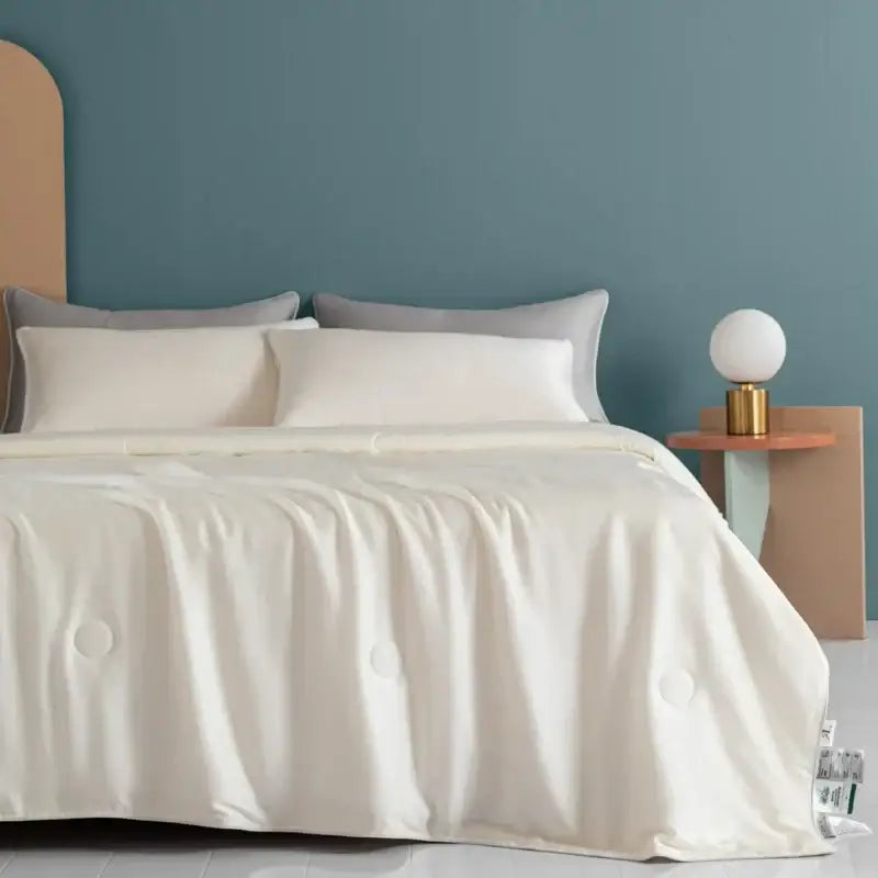 Cream-colored satin decorbites cooling comforter with subtle quilted circular patterns for silky soft bedroom decor