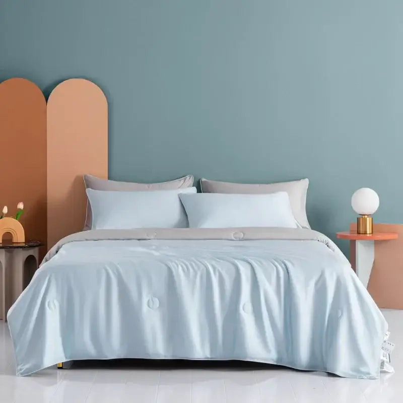 Light blue satin duvet cover with subtle circular embroidery on plush cream cooling comforter by decorbites cooling