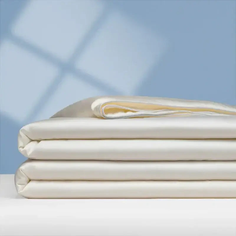 Stack of cream-colored satin sheets with a smooth glossy finish for decorbites cooling comforter bedroom quilt