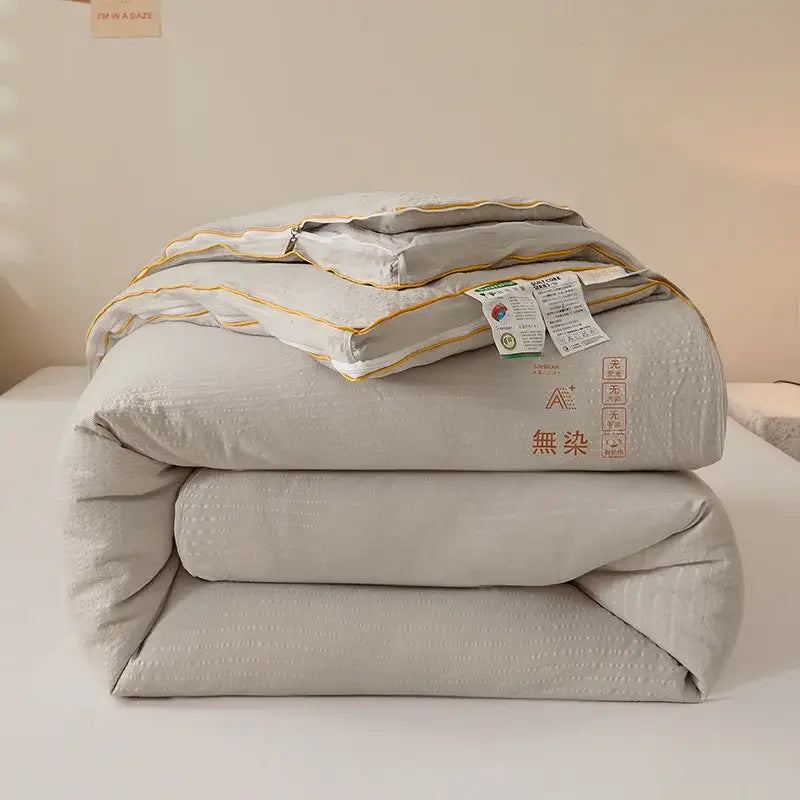 Plush cream cozy soy fiber quilt in soft light gray with subtle texture and gold piping for bedroom bedding decorbites cozy soy