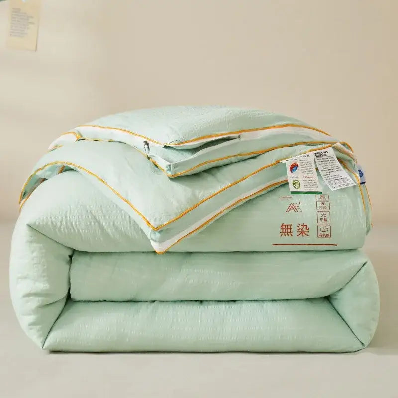 Plush cream cozy soy fiber quilt in soft mint green with gold piping and a subtle textured weave for bedroom decorbites cozy soy
