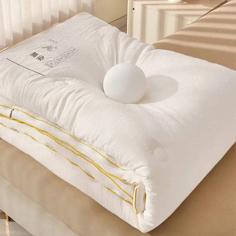 Plush cream cozy soy fiber quilt with yellow stitching and a white spherical pillow for bedroom decorbites cozy soy bedding
