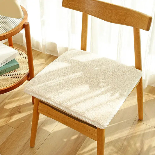 Cream-colored plush wool chair cushion with soft textured lambs wool surface and neatly finished edges for dining comfort