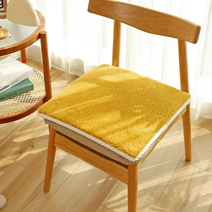 Yellow plush lamb’s wool chair cushion with white crochet trim providing decorbites cozy dining room comfort