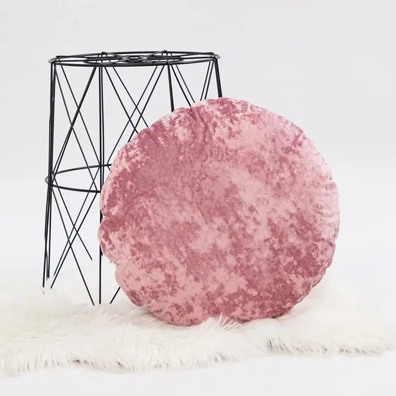 A plush round pink velvet pillow cover with a soft textured surface for living room decor dark grain style