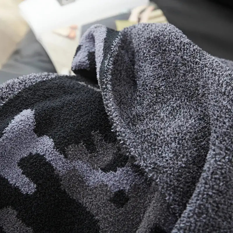 Plush dark gray and black decorbites camouflage knitted throw blanket with soft fuzzy textured surface for bedroom decor