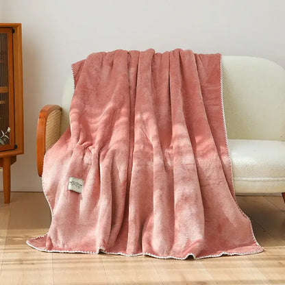 A plush dusty rose decorbites double-layer warm blanket with soft velvety texture and white stitched trim for bedroom use
