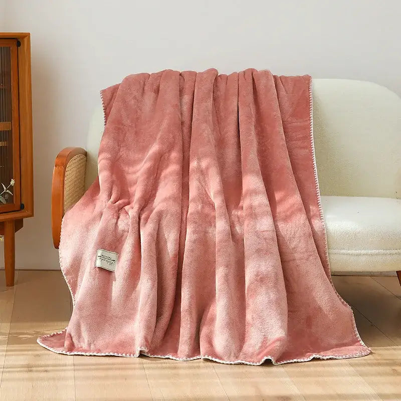 A plush dusty rose decorbites double-layer warm blanket with soft velvety texture and white stitched trim for bedroom use