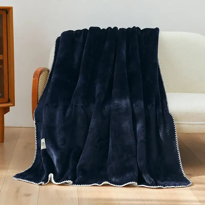 A plush navy blue decorbites double-layer warm blanket with soft velvety texture and white stitched trim for bedroom use