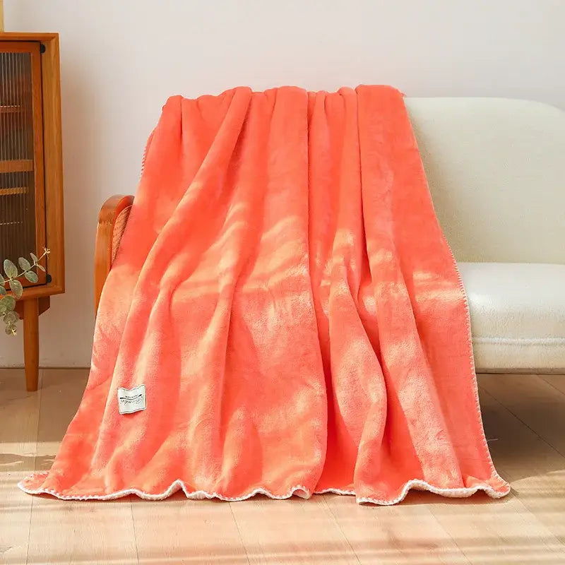 Soft coral-colored plush decorbites double-layer warm blanket with subtle tie-dye pattern and white scalloped edge