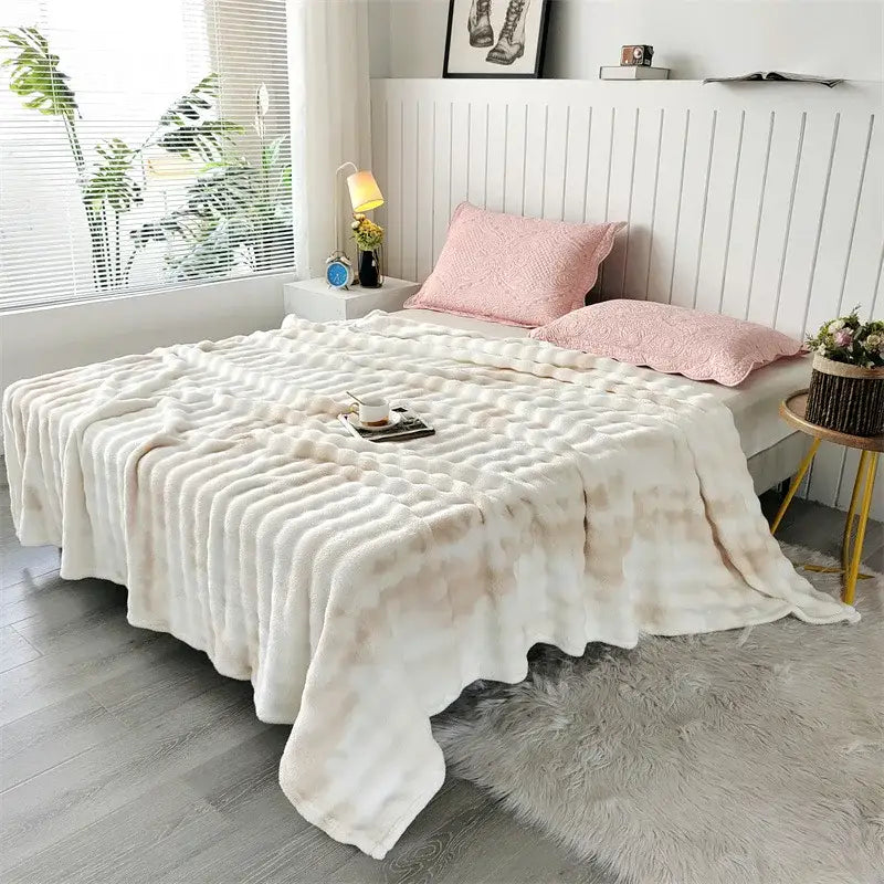 Cream-colored fleece throw blanket with textured wavy pattern and soft plush material for living room use