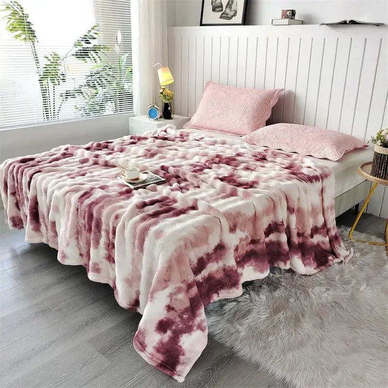 A plush fleece throw blanket in soft pink and white tie dye with fluffy texture for cozy living room use